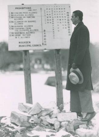 Moe Berg Standing by Sign photograph, undated